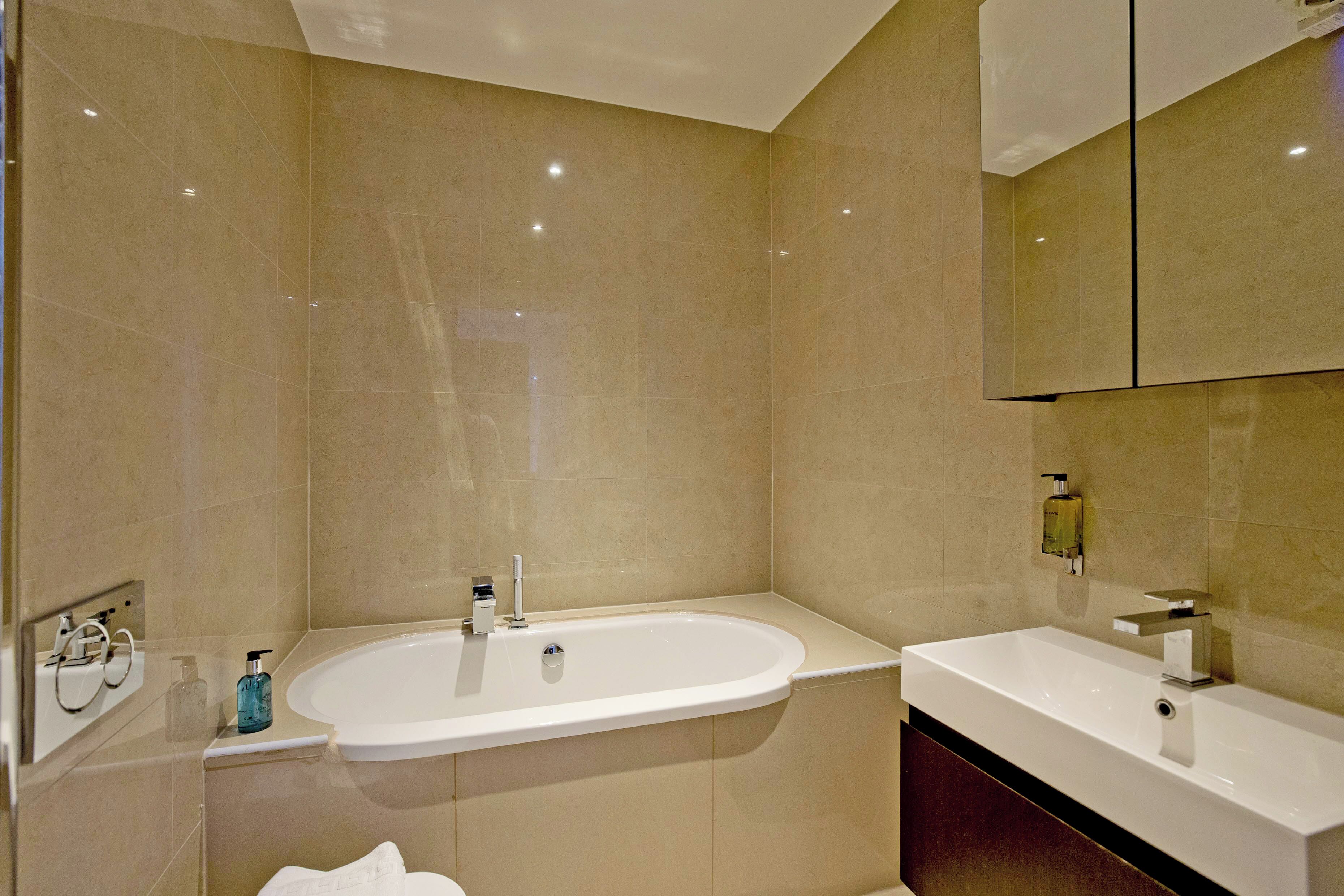A modern bathroom with a freestanding bathtub, a vanity with a mirror, and a toilet.