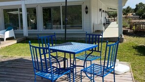 Une terrasse couverte avec une table et des chaises, un hamac et une vue sur le paysage environnant.