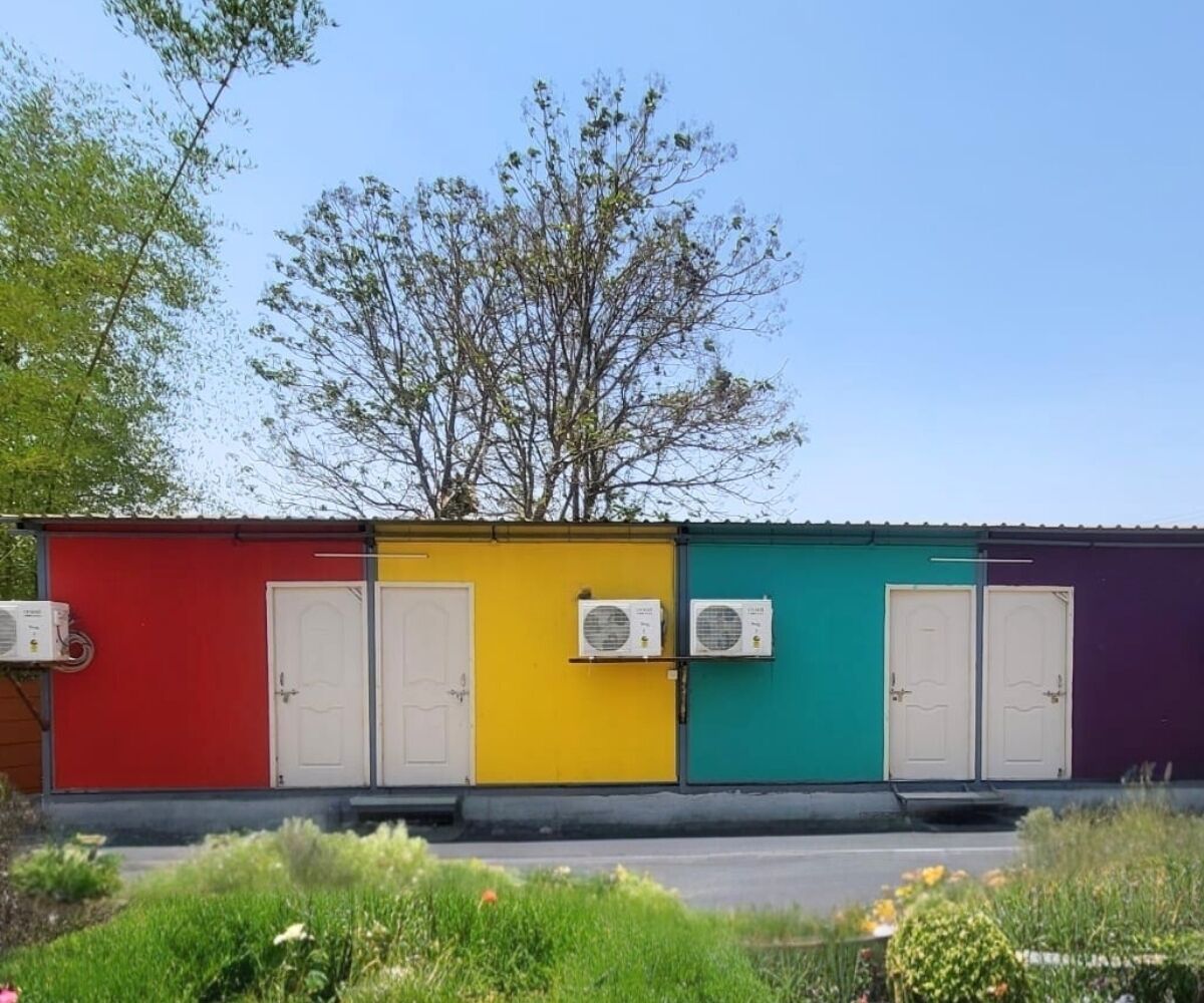A row of colorful portable buildings with air conditioning units and doors.