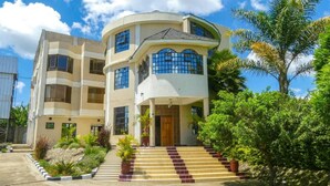 A multi-story building with a curved facade, a central entrance with steps, and a balcony on the upper floor. - Royal Green Gardens (Nakuru)