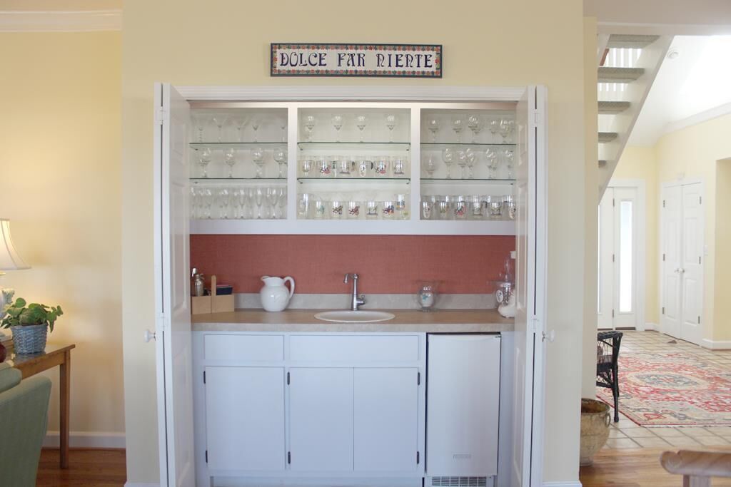 A kitchen with a built-in wine rack, a sink, and cabinets.