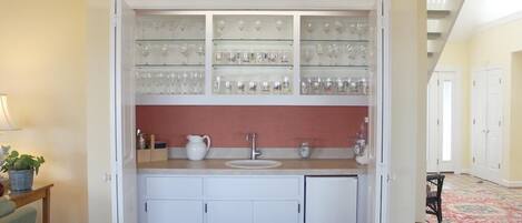 A kitchen with a built-in wine rack, a sink, and cabinets.