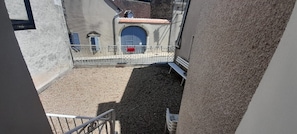 A courtyard with a metal fence, a red mailbox, and a blue door. - 2 bedroom apartment with terrace- Wifi in the heart of Levroux (Levroux)