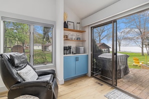 Relax in a cozy seating area with a leather recliner and enjoy a coffee station with a coffee maker and a jar.