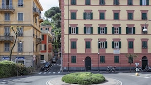 A street corner with a roundabout, buildings with multiple stories, and parked vehicles. - Appartamento Centrale con Terrazzo by Wonderful Italy (Santa Margherita Ligure)