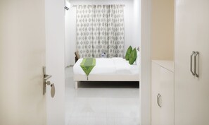 Una habitación de hotel con cama, puerta de baño y armario.