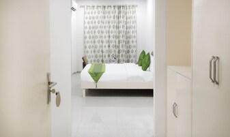 Una habitación de hotel con cama, puerta de baño y armario.