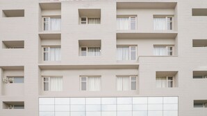 A multi-story hotel building with a sign indicating rooms are available.
