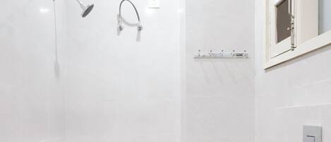 A modern bathroom with a shower, a toilet, and a sink.