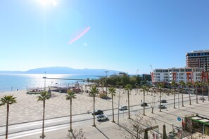 A coastal promenade with palm trees, a beach, and a view of the sea. - Luna Sea View Apartment 5 floor (Vlorë)