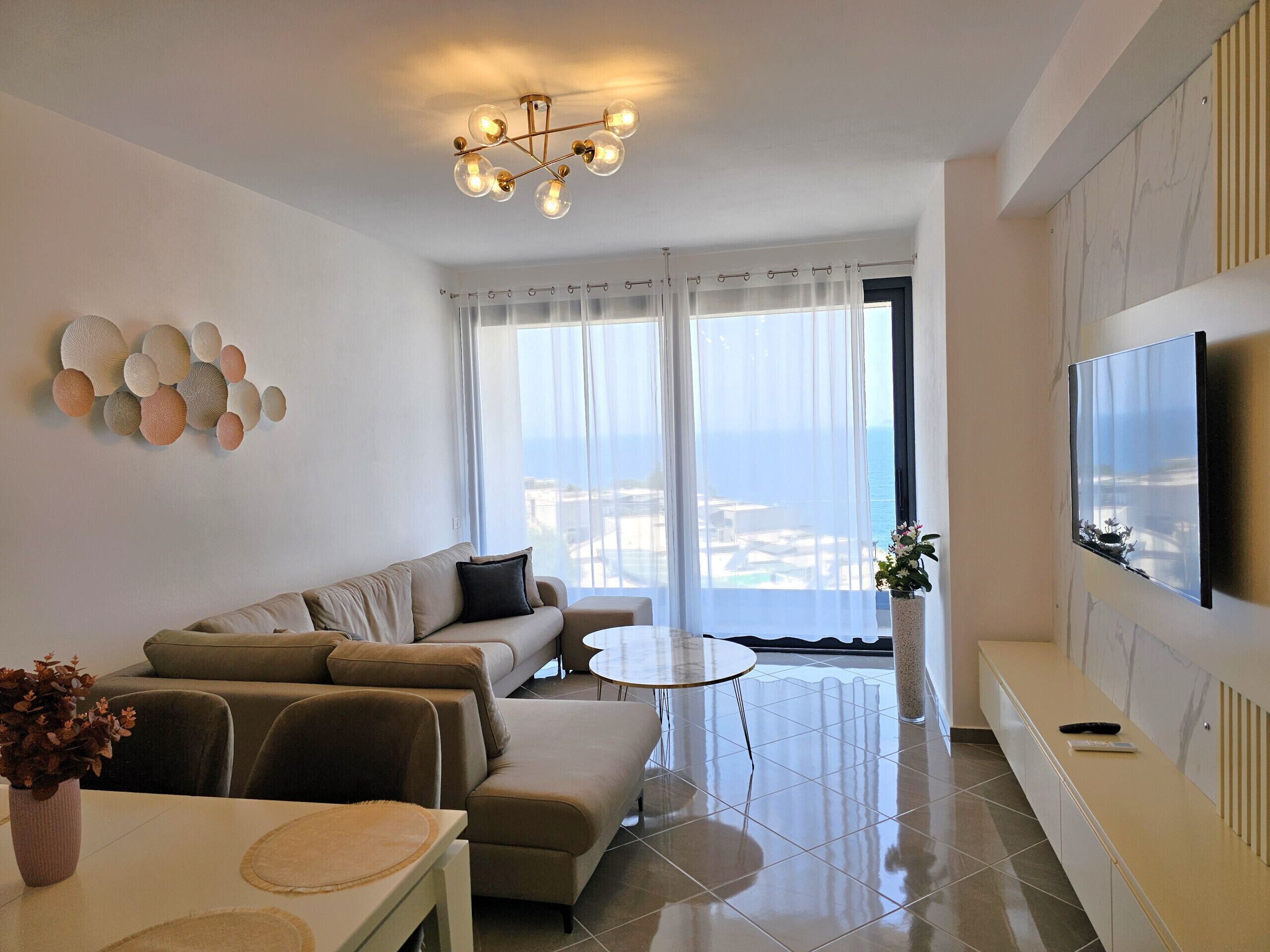 Una sala de estar moderna con un sofá, una mesa de centro y un televisor montado en la pared.