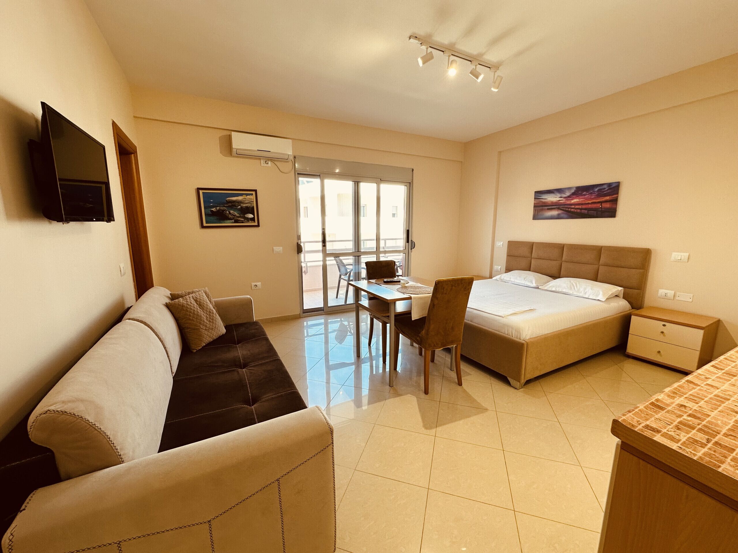 A hotel room with a bed, a sofa, a desk, and a chair.