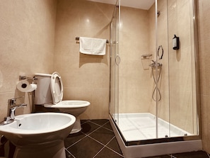A bathroom with a toilet, bidet, and a glass-enclosed shower area. - Thoma's K Studios – Double Studio with Balcony (Vlorë)