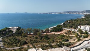 A coastal view with a beach, buildings, and a road.