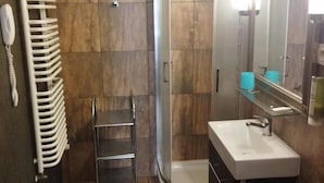 A modern bathroom with a shower, a sink, and a towel rack. - Great Polonia Kraków Kazimierz  (Kraków)