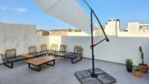 A rooftop terrace with outdoor seating and a large umbrella. - Modern penthouse close to Arenal beach with big top veranda. (Jávea)