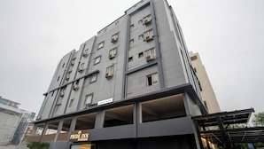 A multi-story hotel with a modern design, featuring balconies and a covered entrance area. - Treebo Pride inn Raidurg (Hyderabad)