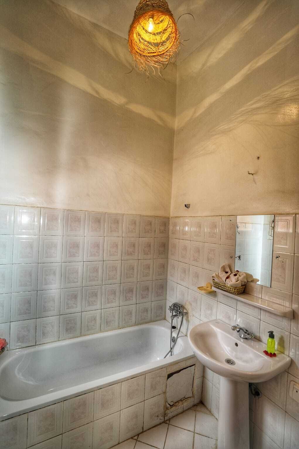A bathroom with a bathtub, a sink, and a mirror.