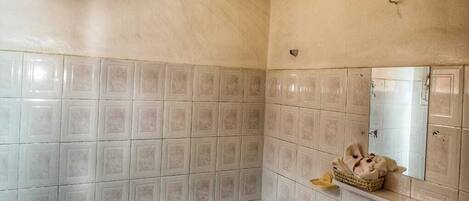 A bathroom with a bathtub, a sink, and a mirror.
