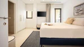 Habitación de hotel moderna con una cama grande, televisión de pantalla plana, un cuadro en la pared y vistas de la ciudad desde la ventana.