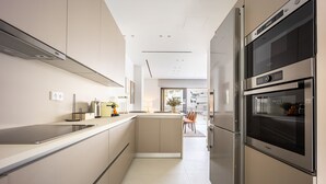Una cocina moderna con una isla central, electrodomésticos de acero inoxidable y vistas al comedor.
