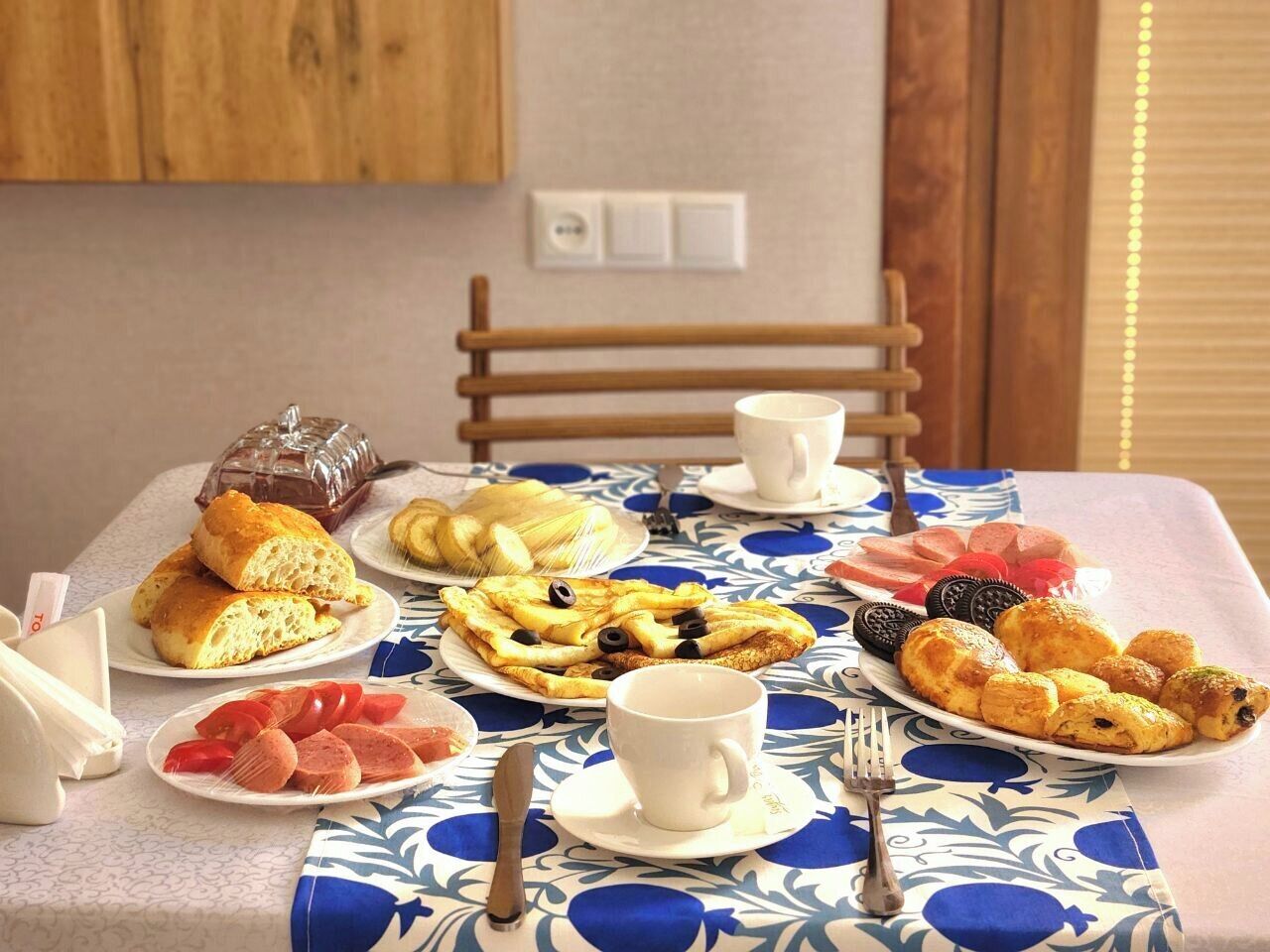 A breakfast table with various pastries, a cup, and a fork.