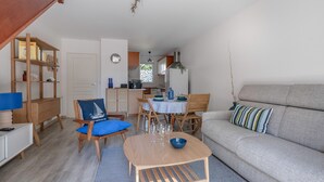 Een ruimtelijk ingerichte leefruimte met een eethoek, een bank en een houten salontafel.