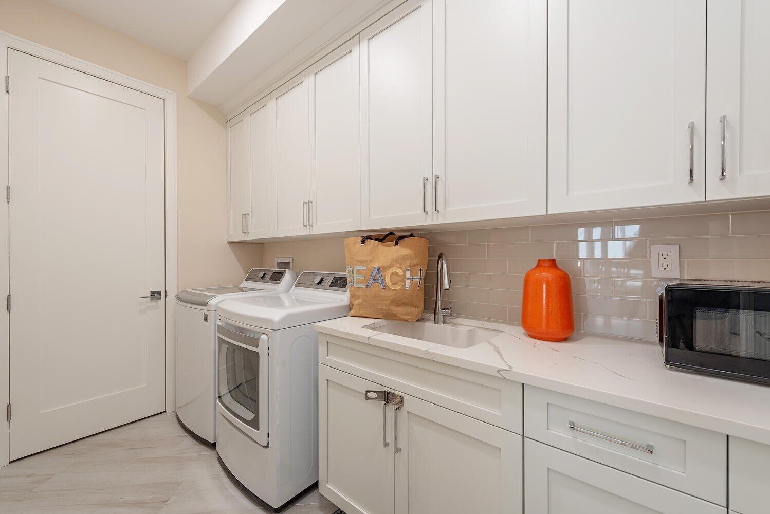 A laundry room with a washing machine, dryer, and a bag of detergent on the counter.