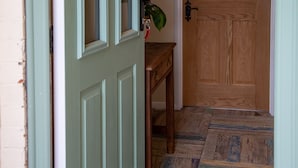 A hallway with a green door, a wooden door, and a patterned floor. - 3 Bedroom idyllic countryside cottage in the middle of rural Wiltshire (Coate)