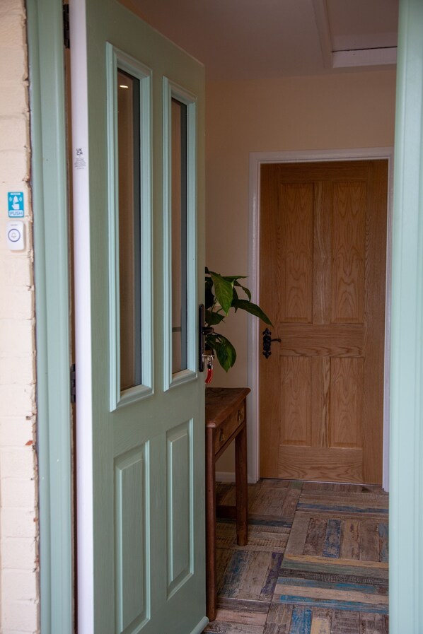 A hallway with a green door, a wooden door, and a patterned floor. - 3 Bedroom idyllic countryside cottage in the middle of rural Wiltshire (Coate)