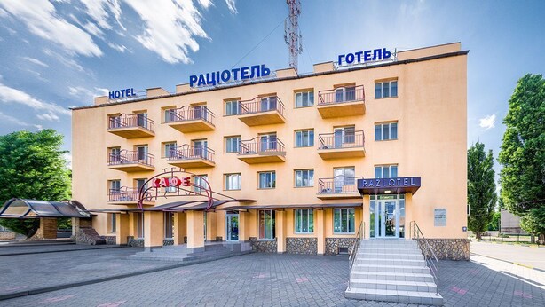 A hotel with multiple balconies, a central entrance, and a sign indicating it is a hotel.