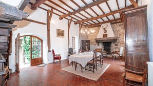 A rustic dining area with a stone fireplace, wooden beams, and a tiled floor. - Clos Saint Michel - Pool - Nature and Calm (Saint-Michel-de-Vax)