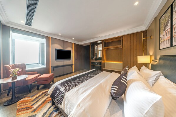 Spacious Deluxe Room with Jacuzzi | Meja kerja, setrika/meja setrika, dan seprai linen