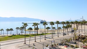 A coastal promenade with palm trees, a beach, and a cruise ship in the background. - Seascape Sea view Apartment (Vlorë)