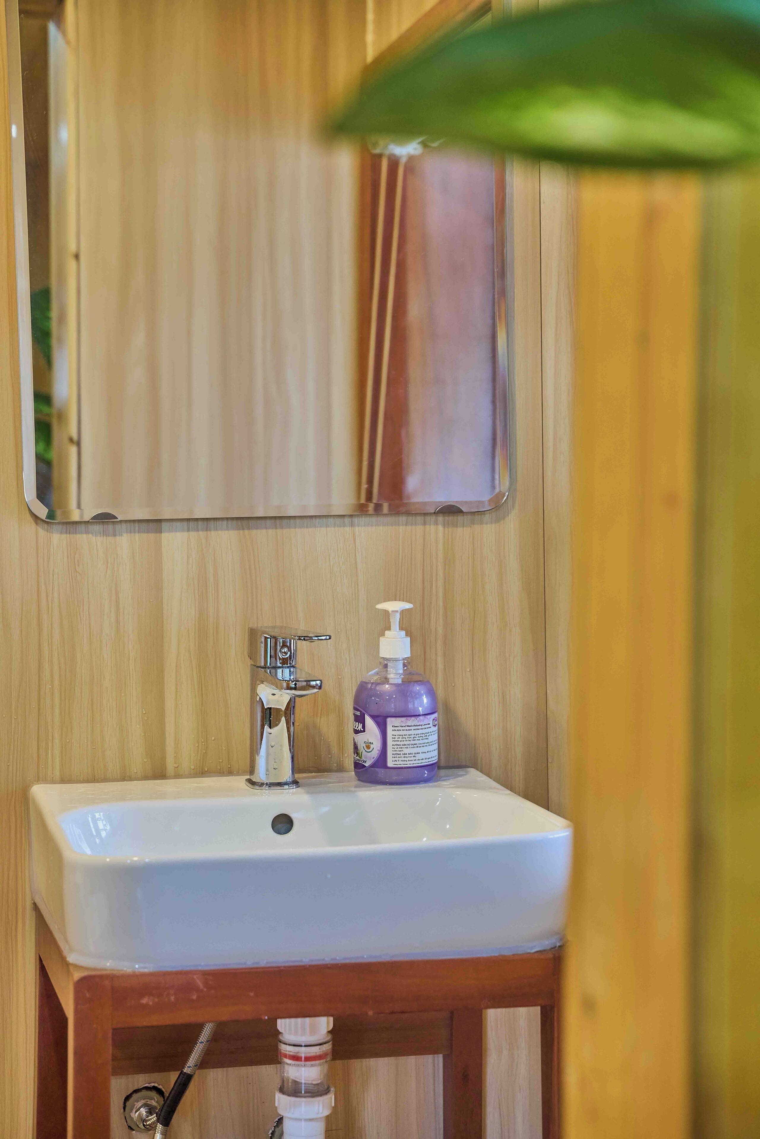 Une salle de bain avec un meuble-lavabo en bois, un lavabo blanc et un miroir au-dessus.