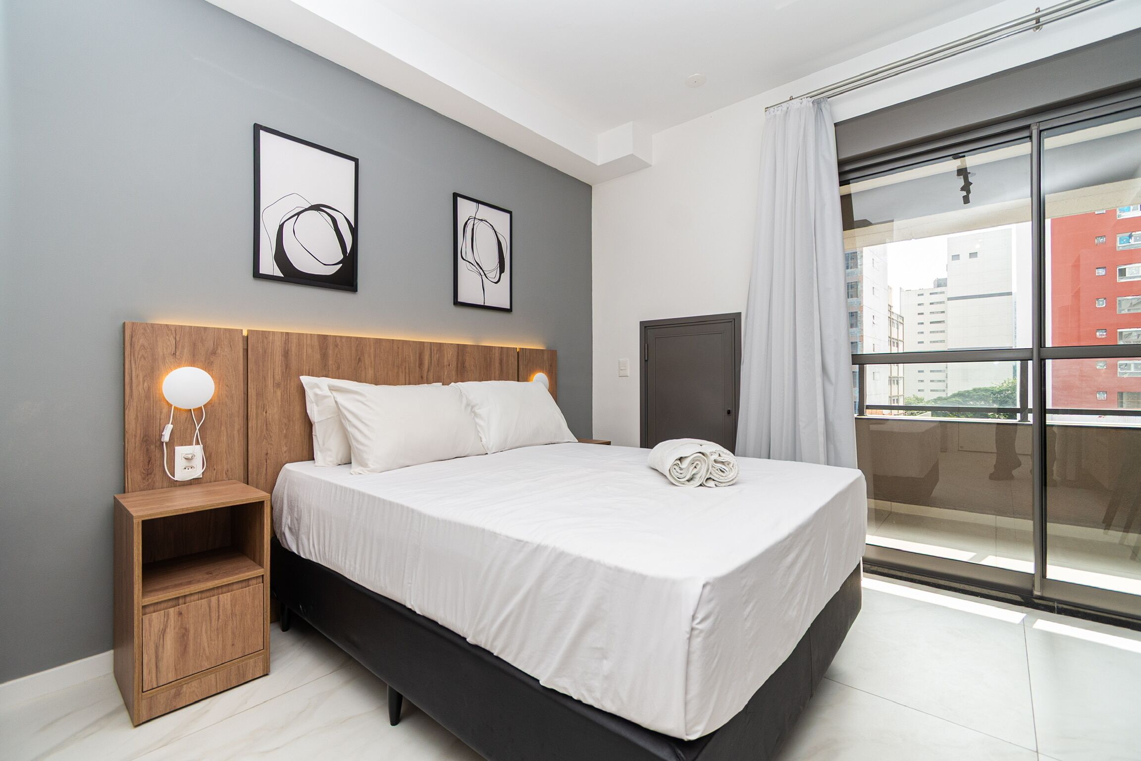 Un dormitorio moderno con una cama grande, mesitas de noche y una obra de arte en la pared.