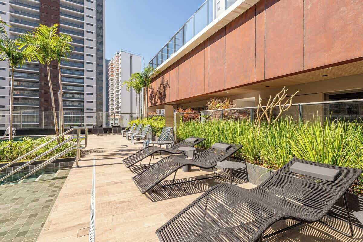Una terrazza panoramica con area relax all'aperto, piscina e vista sugli edifici circostanti.