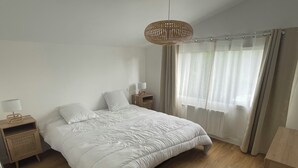 A bedroom with a large bed, wooden nightstands, a bedside lamp, and a hanging light fixture. - New, seaside house, Beg meil, for groups and families  (Fouesnant)