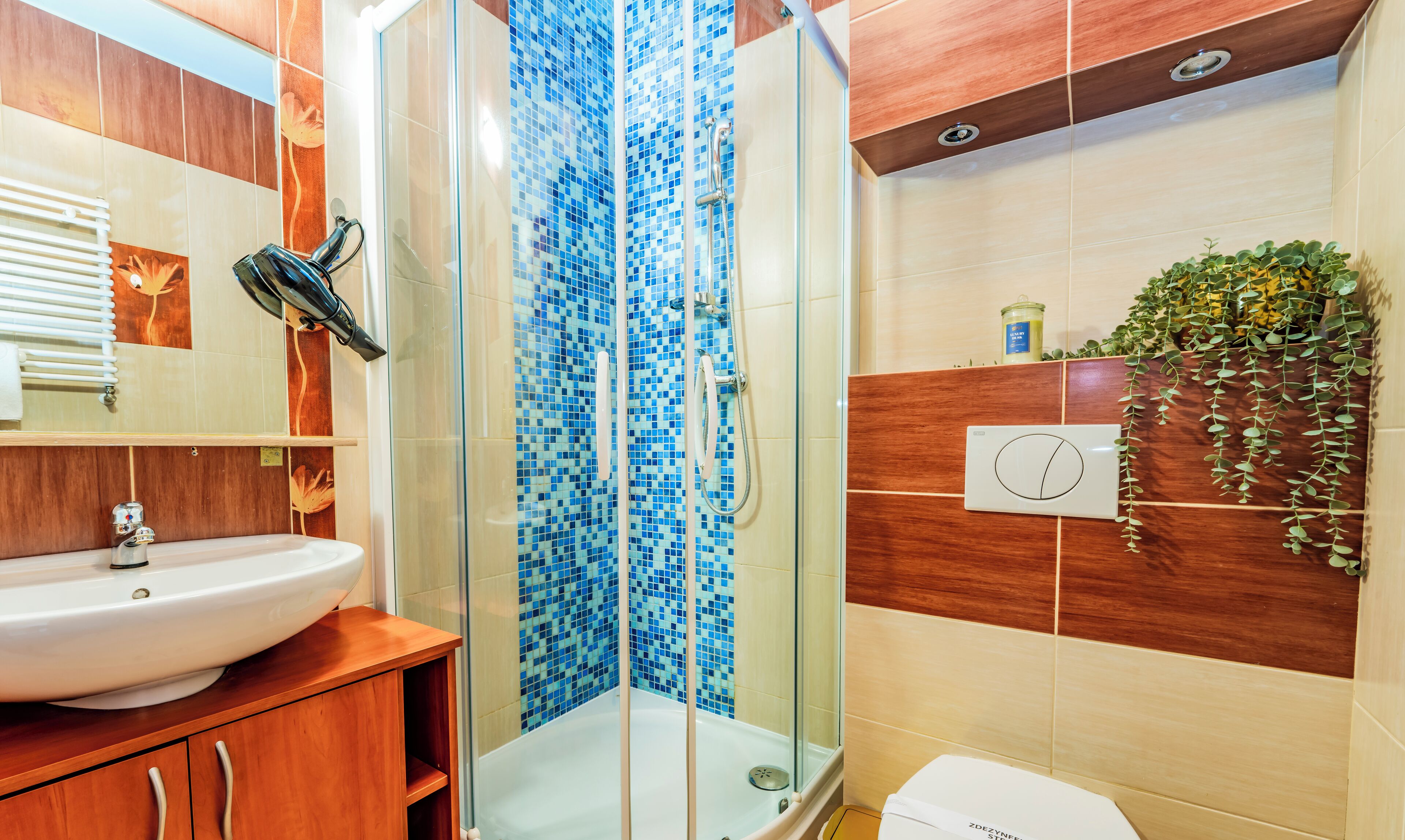 A bathroom with a glass-enclosed shower, a sink, and a toilet.