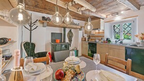 Un espace repas doté d’un plafond en bois, de luminaires suspendus et d’une table mise pour le repas.