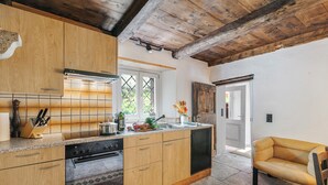 Une cuisine avec des meubles de rangement en bois, un four encastré et un évier.