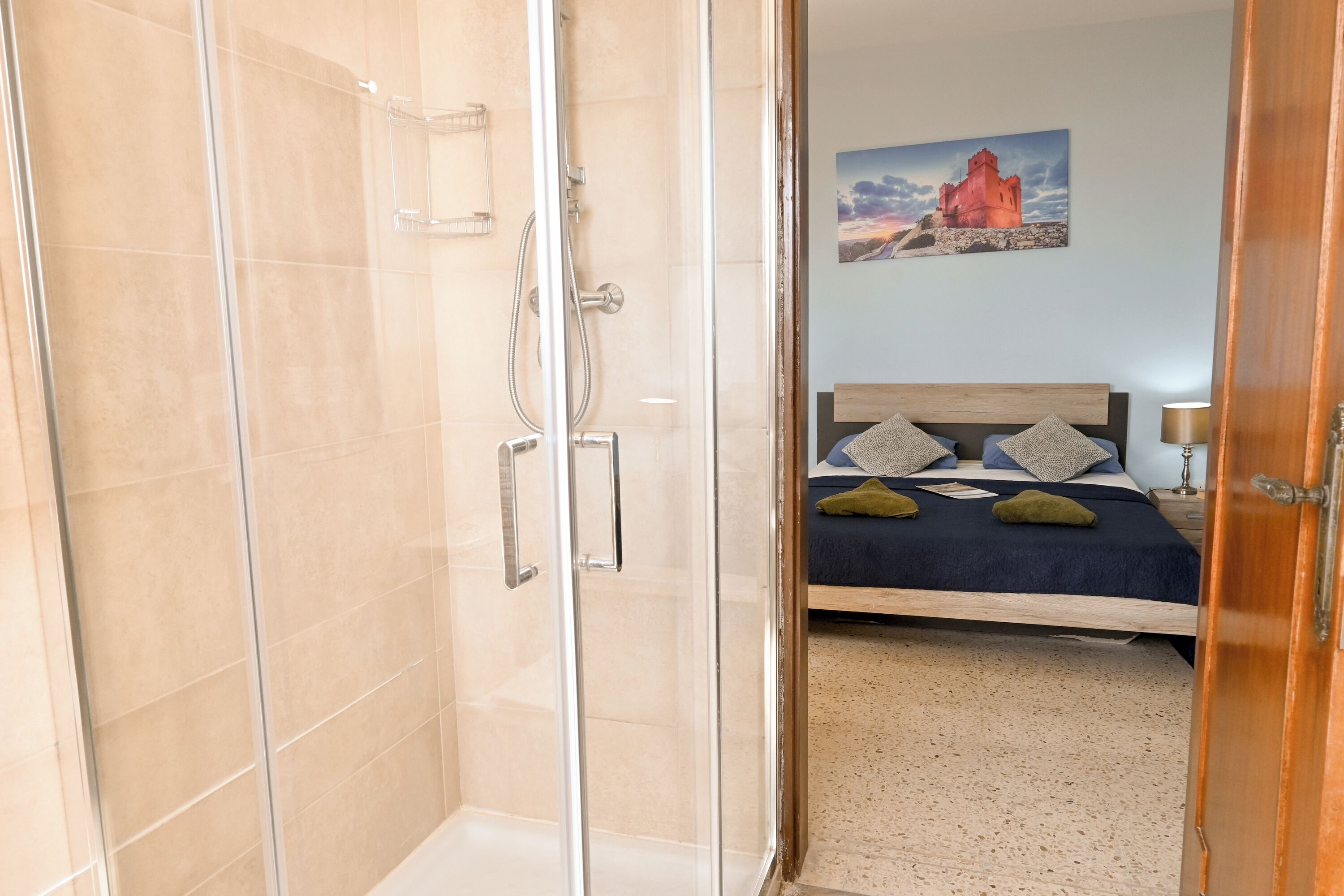 A modern bathroom with a glass shower enclosure and a visible showerhead.