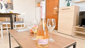 A bottle of Rosat Prosecco DOC Gavi on a wooden table with two empty wine glasses.