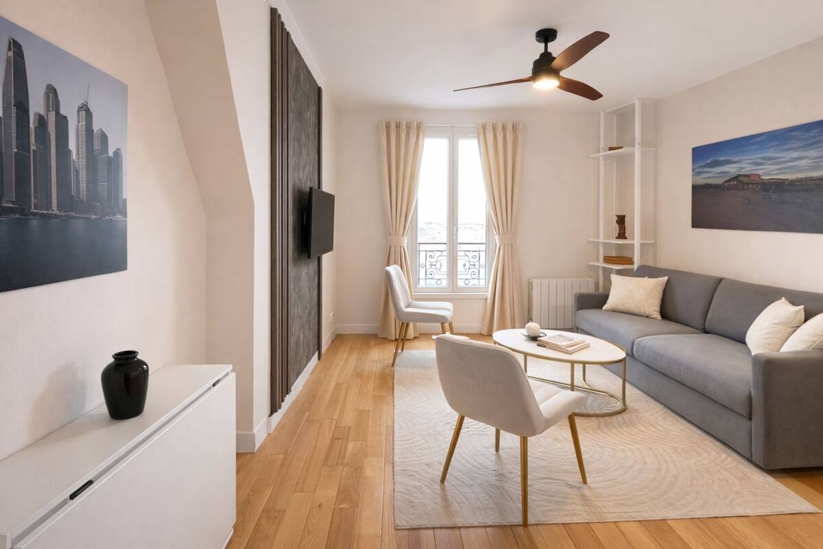 A modern living room with a sofa, chairs, a coffee table, a TV, and a cityscape painting.