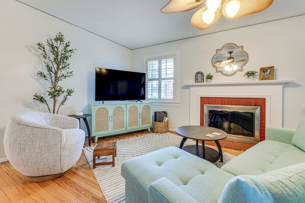A living room with a television, a fireplace, a sofa, and a chair. - 4 Mi to Dtwn Jacksonville: Chic Home w/ Porch! (Jacksonville)