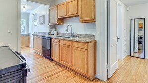 A kitchen with wooden cabinets, a granite countertop, and a dishwasher. - 4 Mi to Dtwn Jacksonville: Chic Home w/ Porch! (Jacksonville)