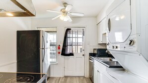 A compact kitchen with a black stove, white cabinets, a microwave, and a ceiling fan. - Condo 9 Mi to Dtwn Dallas: BBQ By the Pool! (Dallas)