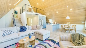 Egy modern, loft-stílusú lakótérrel, konyhával és étkezővel berendezett belső tér.