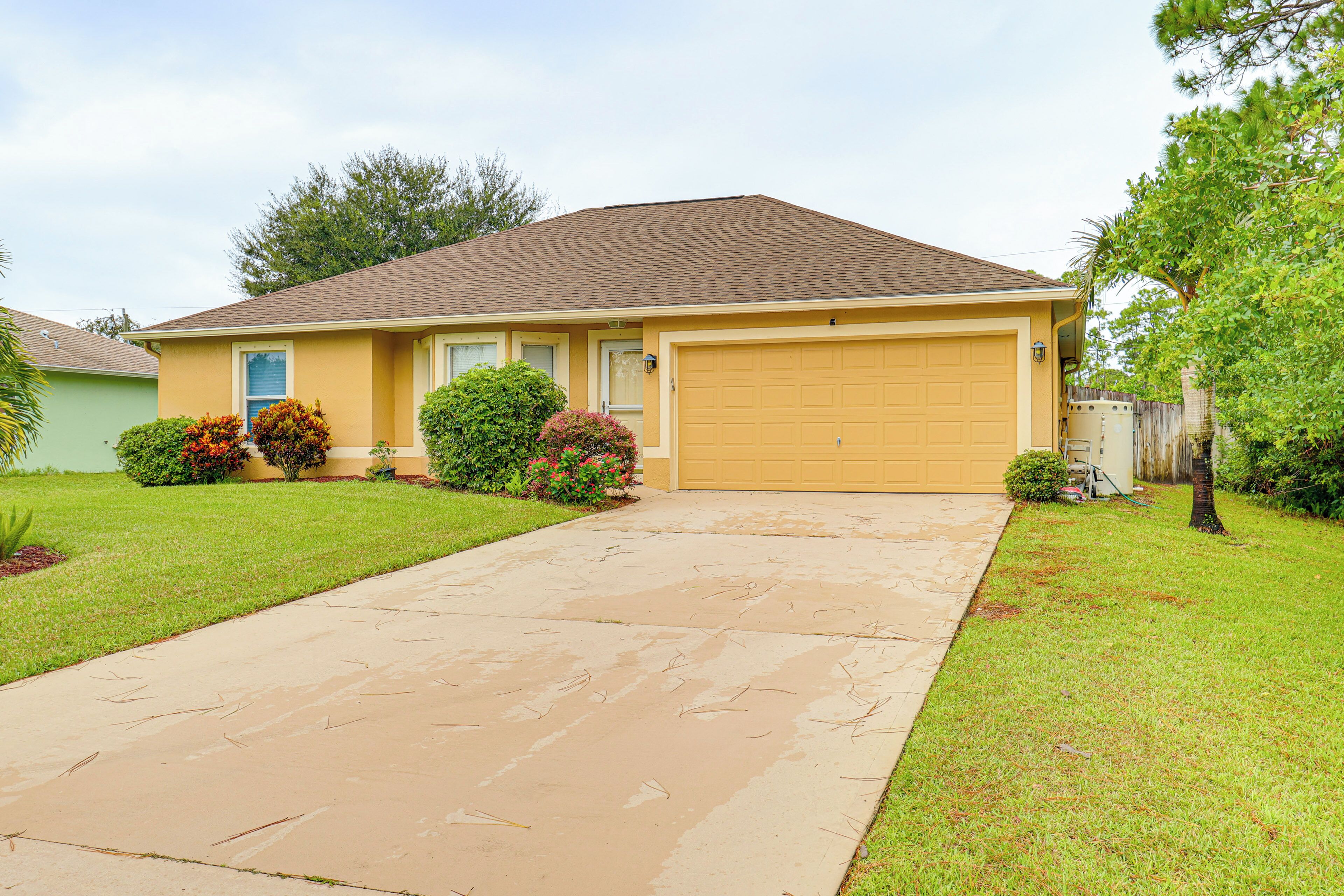 A single-story house with a garage, a front lawn, and a driveway.