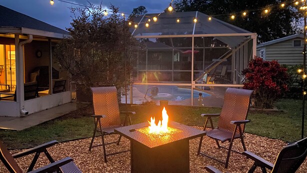 An outdoor patio with a square fire pit, surrounded by four chairs. - Pool & Fire Pit: Family-friendly Palm Bay Home! (Palm Bay)